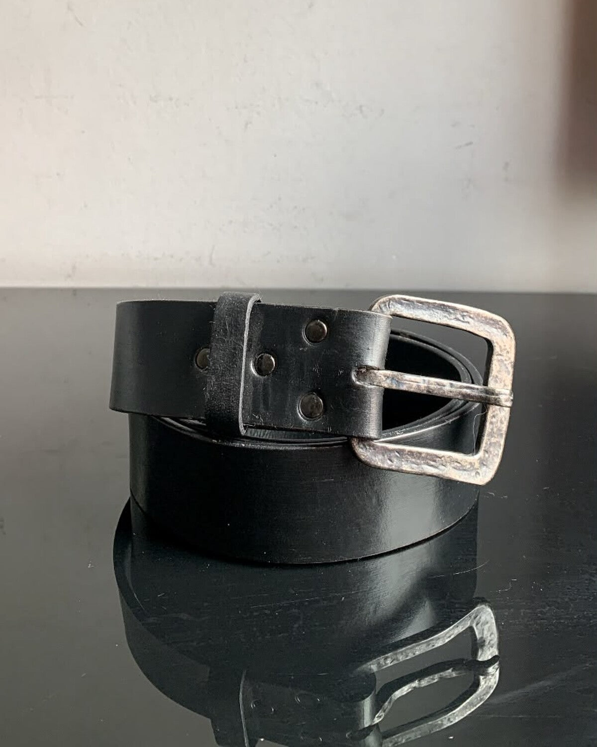 Aevum black leather belt coiled with hammered metal buckle
