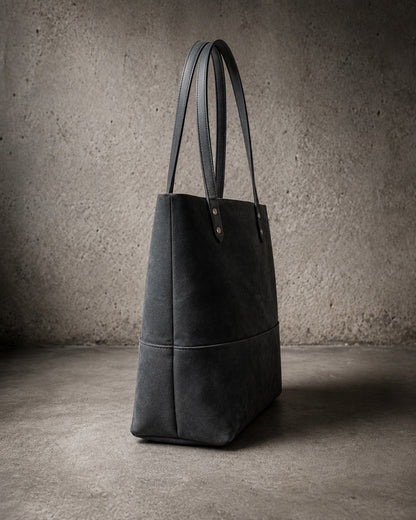 Imminent Occurrence leather tote bag side angle in dry charcoal leather