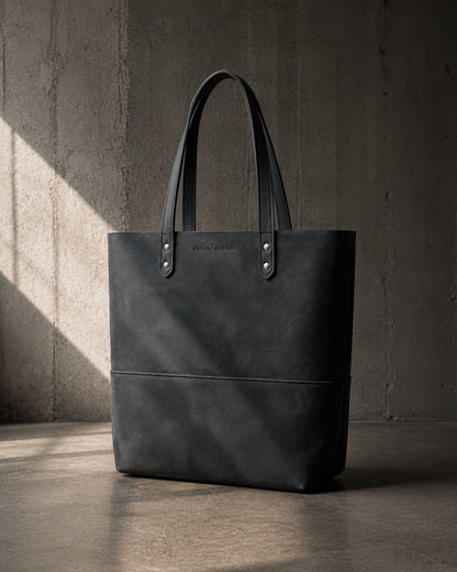 Imminent Occurrence leather tote bag in dry charcoal black leather, three quarter view