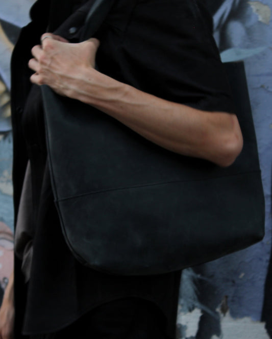 Tim carrying the Imminent Occurrence charcoal leather tote