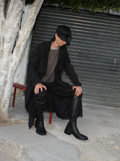 Model seated in the Imminent Occurrence handmade leather trench coat