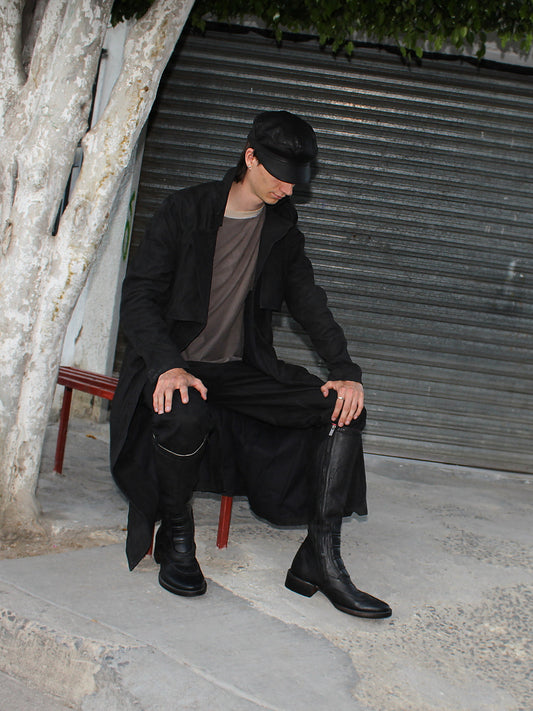Model seated in the Imminent Occurrence handmade leather trench coat